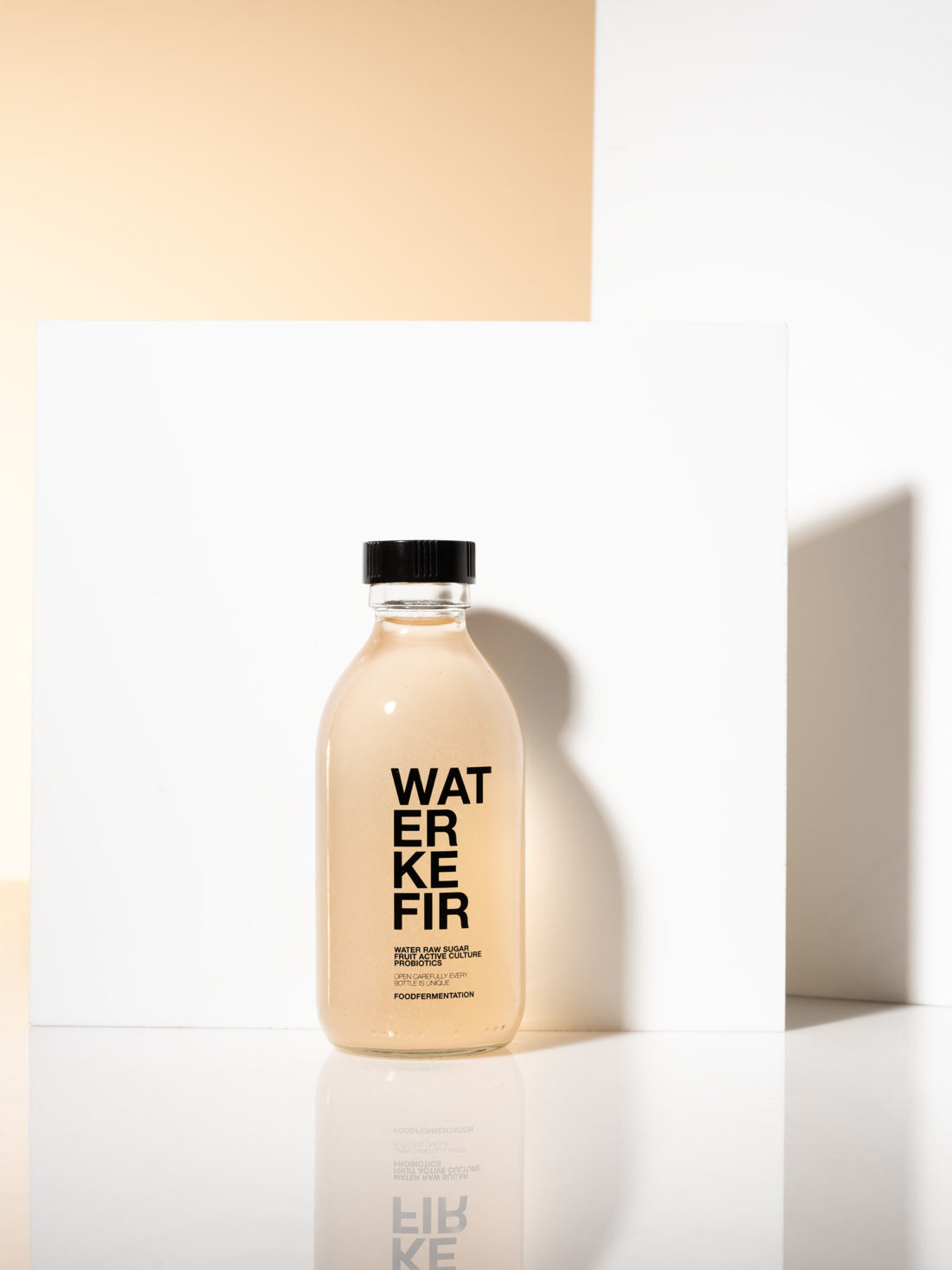 Water kefir flaska fotograferad i studio med skuggspel