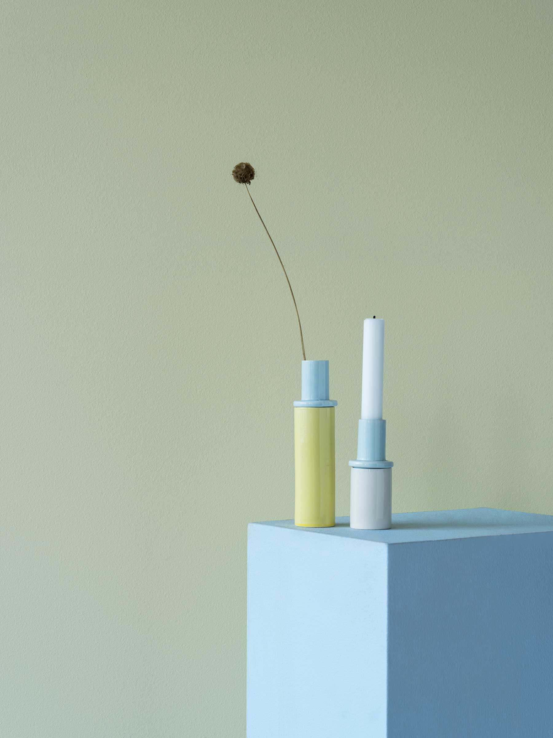 minimalistiskt stilleben av keramikvas och ljusstake i studio